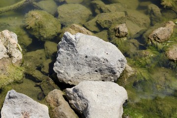A close view on the rocks and stones in the water surface.