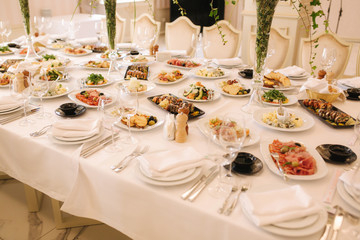 Table with mixed food. Banquet in restaurant, table setting. Differend meals for the guests. Fresh food