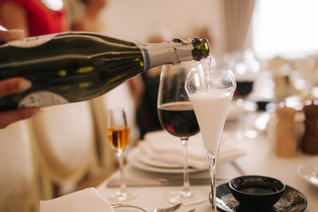 Waiter pours champagne into a glass. Banquet concapt
