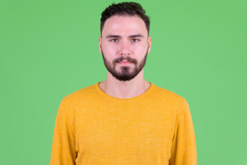 Face of young handsome bearded man looking at camera