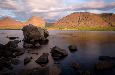 Summer sunset at coast of Westfjords with mighty rocks in foreground and beautiful lighted mountains in background, Vestfirðir, Iceland © sg-naturephoto.com 