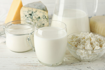 Different dairy products on white wooden background, close up