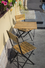 Two chairs and a table on the street near the house