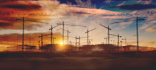 Gruas de construcción y puesta de sol.Concepto de industria y mercado inmobiliario..Cimientos de...