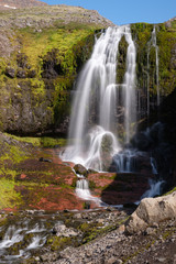 High waterfall in Westfjords mountain landscape, Iceland
