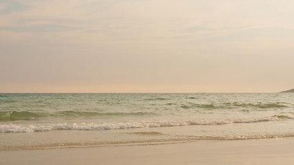 Ocean beach waves on tropical beach at sunset time, sunlight beautiful evening nature sea background.