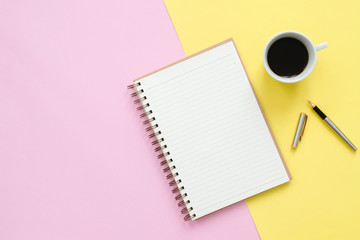 Creative flat lay photo of workspace desk. Top view office desk with mock up notebooks, plant, coffee cup and copy space on pastel color background. Top view with copy space, flat lay photography.