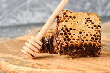 honeycomb with honey on a wooden Board, and a spoon for honey, selective focus