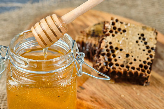 honeycomb with honey on a wooden Board, with a spoon of honey, selective focus