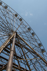 Ferris wheel in sunny summer Sochi under blue cloudy sky