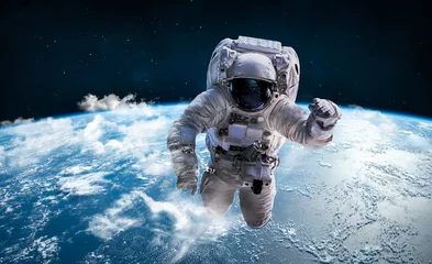 Poster Astronaut in de ruimte boven de planeet aarde. Wolken op de achtergrond. Ruimtevaarder. Elementen van deze afbeelding geleverd door NASA © dimazel