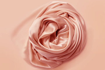 beautiful satin fabric draped with soft folds in a rose, silk cloth background, close-up, copy space