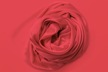 beautiful red satin fabric draped with soft folds in a rose, silk cloth background, close-up, copy space