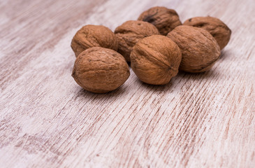 Whole walnuts on cream colored wood, healthy food