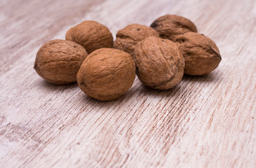 Whole walnuts on cream colored wood, healthy food