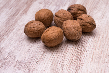 Whole walnuts on cream colored wood, healthy food