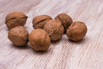 Whole walnuts on cream colored wood, healthy food