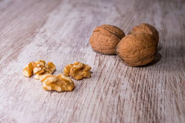 Whole walnuts on cream colored wood, healthy food