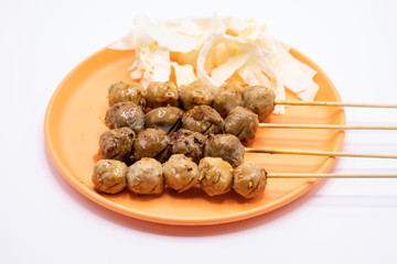 Grilled meatballs on a wooden stick with in orange plate isolate on white background.