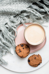 Beautiful enameled cup of coffee with cookies and knitted blanket
