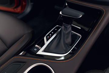 Naklejka na ściany i meble Selector automatic transmission with perforated leather in the interior of a modern expensive car. The background is blurred