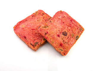 Two slices of bread made from beet fruit and mixed raisins, on a white background.