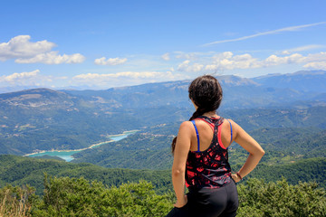 Hiker girl in the mountains scrutinizes the landscape