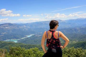 Hiker girl in the mountains scrutinizes the landscape