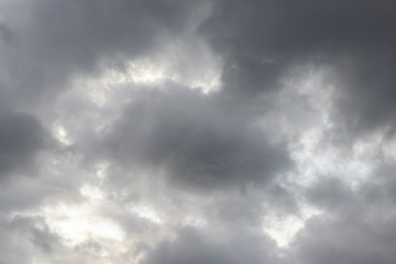 Dark heavy clouds. Rain clouds. Time before the rain. There are bright gaps behind the clouds. Background with free space and empty place.