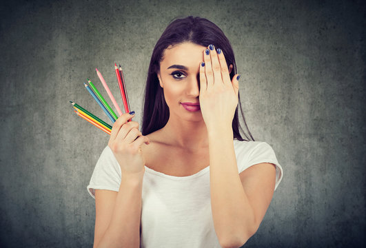 woman with colorful crayons on wall background