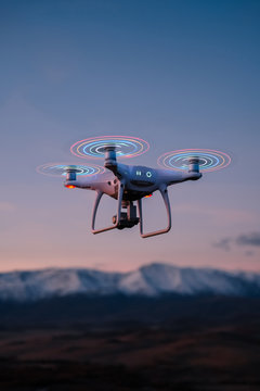 quadrocopter with glowing blades flies and shoot the sunset and nature