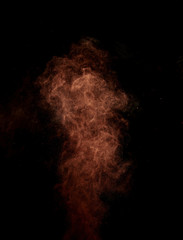 Cocoa powder explosion in motion. Chocolate powder on a black background