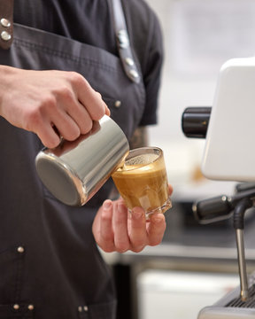 Barista make coffee latte with espresso machine in coffee shop cafe.