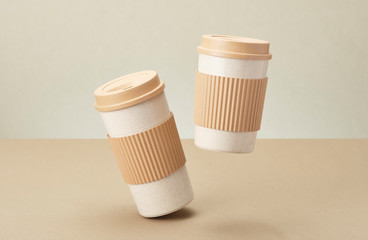 Two Eco Coffee Cup Isolated on Beige Background