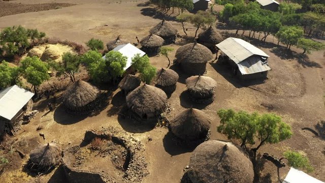 Retreating aerial footage flying over small village with classic thatched rooftops, culture traditions rural population Ethiopia Africa