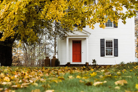 classic New England home with maple tree in the fall