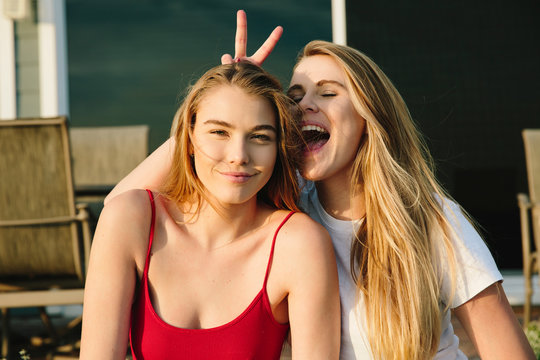 Surfer girls messing around and having a great time.