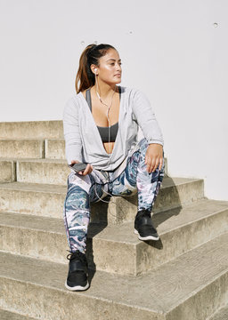 Athletic plus size woman taking a break on her phone