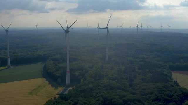 Aerial view of wind turbines close to Berlichingen in Germany. Pan to the right from the front of the turbines.