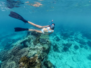 Woman diving In Blue Water With Dive Mask and fins