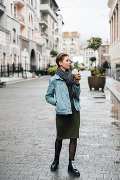 Young woman with beverage on street