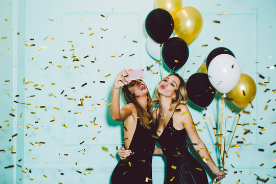 Beautiful women taking a selfie in a New Year party celebration.