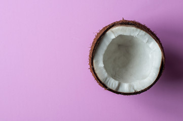 Half coconut on a pink background. Copy space