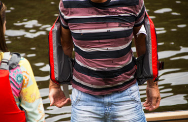 Obraz na płótnie Canvas a man in a striped wet shirt takes off his life vest