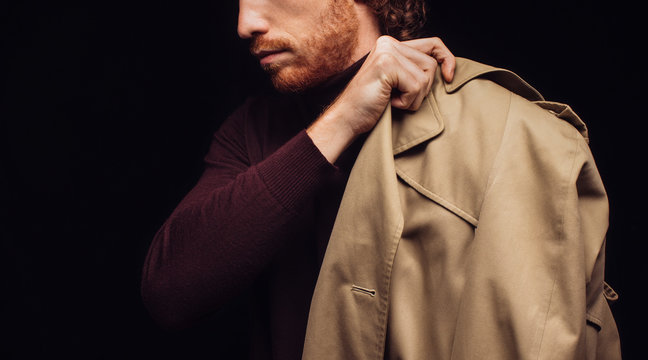 A Man Holding a Trench Coat