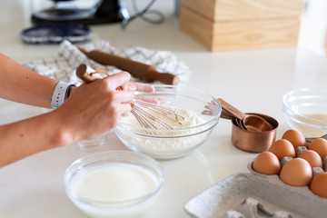 woman whisking flour in kitchen