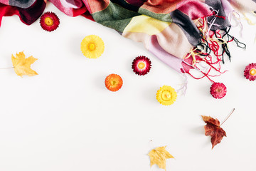 Autumn cozy composition. Dry leaves, flowers, checkered plaid on white background. Fall concept. Autumn background. Flat lay, top view, copy space