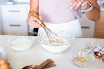 woman whisking flour in kitchen