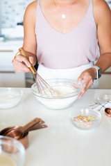woman whisking flour in kitchen