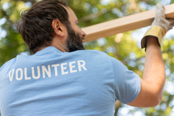 Volunteer carrying wood